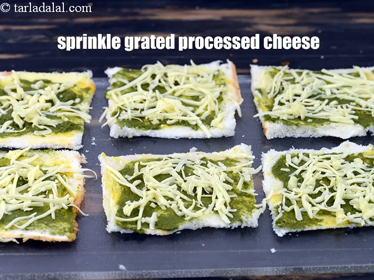 Step 12 – Sprinkle &frac12; tbsp of <a href="https://www.tarladalal.com/glossary-grated-processed-cheese-868i">grated processed cheese</a> on each bread slice.