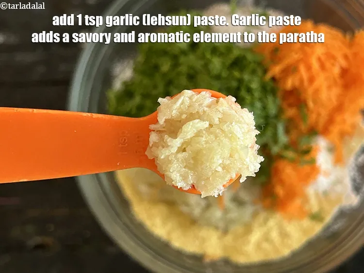 Step 13 – Add 1&nbsp;tsp&nbsp;<a href="glossary-garlic-paste-lehsun-ki-paste-lahsun-ki-paste-350i">garlic (lehsun) paste</a>.&nbsp;Garlic paste adds a savory and aromatic element to the paratha.