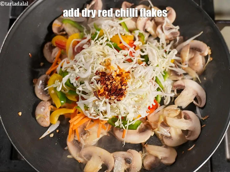 Step 13 – Add 1 tsp <a href="https://www.tarladalal.com/glossary-dry-red-chilli-flakes-paprika-338i">dry red chilli flakes (paprika)</a>.