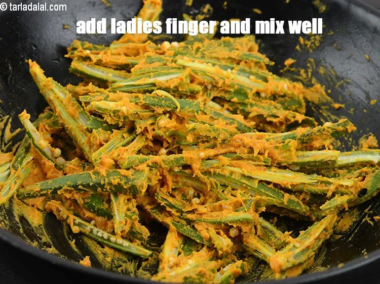 Step 40 – Add 2 cups <a href="https://www.tarladalal.com/glossary-ladies-finger-bhindi-okra-bhinda-lady-finger-491i">ladies finger (bhindi)</a>, into four lengthwise.&nbsp;Mix well.