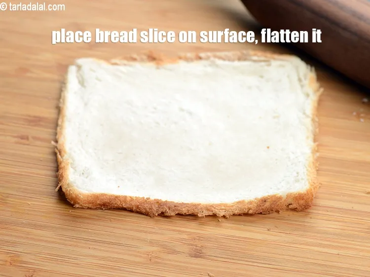 Step 13 – To make <strong>baked bread samosa,</strong> place a bread slice on a clean dry surface, flatten …