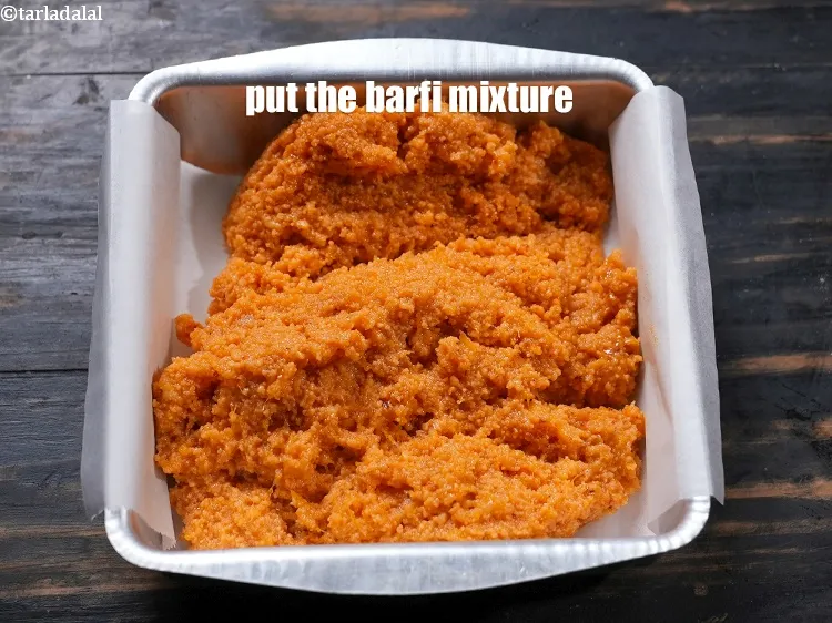 Step 13 – Put the orange barfi mixture in the lined tine.