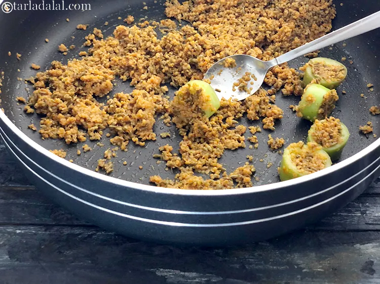 Step 13 – Stuff the mustard chilli pickle masala into the bhavnagri chilli roundels with a spoon.&nbsp;