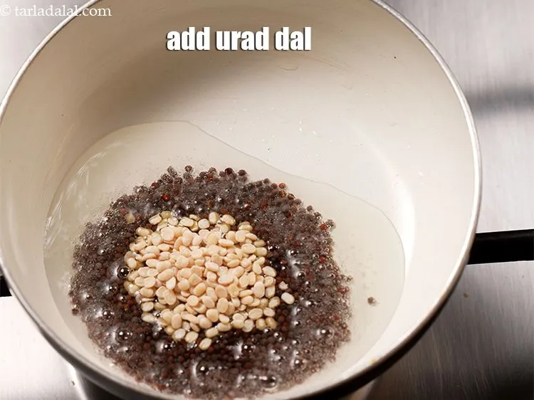 Step 14 – Add 1 tsp <a href="https://www.tarladalal.com/glossary-urad-dal-split-black-lentil-941i">urad dal (split black lentils)</a>.