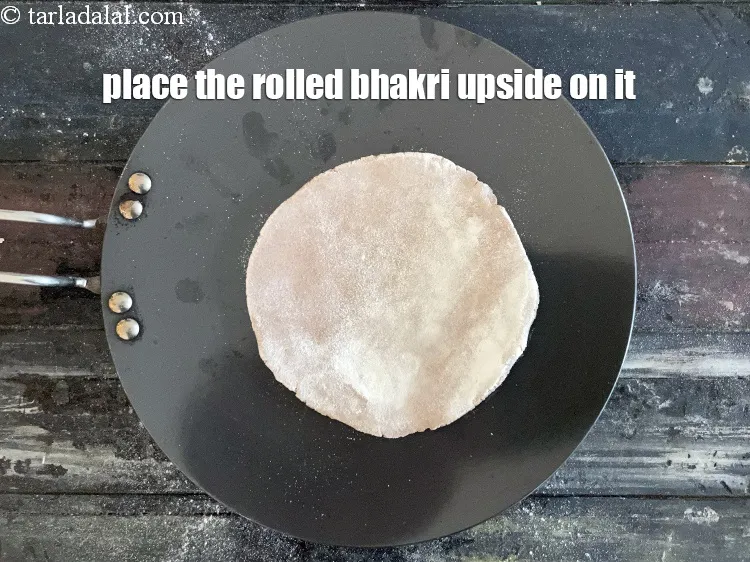 Step 15 – Place the rolled bhakri dough upside down on it.