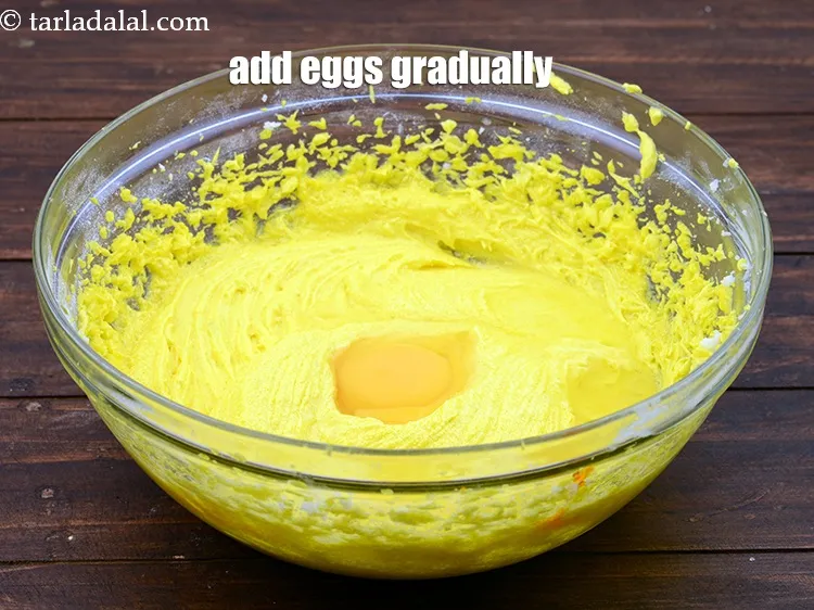 Step 14 – Add 4&nbsp;<a href="https://www.tarladalal.com/glossary-eggs-398i">eggs</a> one by one gradually while beating occasionally.