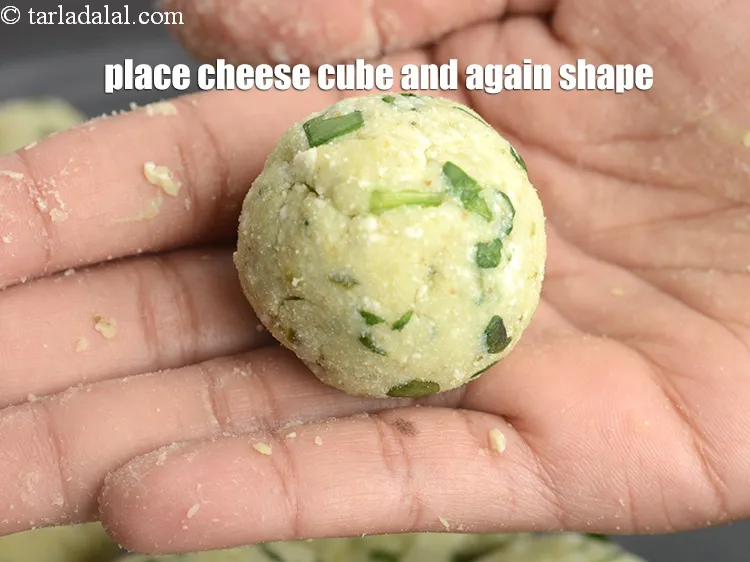 Step 12 – Place a piece of cheese cube in it and again shape them into a round …