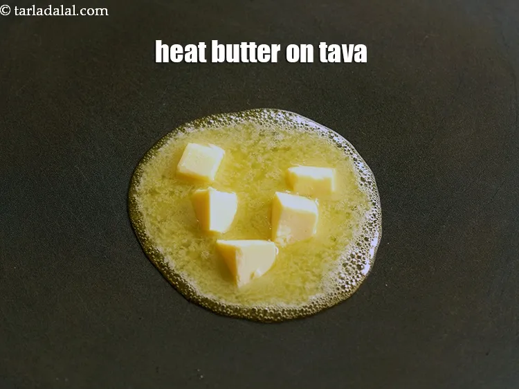 Step 13 – Heat 2 tbsp of <a href="https://www.tarladalal.com/glossary-butter-makhan-233i">butter</a>&nbsp;on a non-stick tava (griddle).