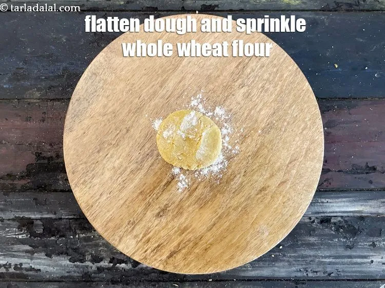 Step 17 – Sprinkle a little&nbsp;<a href="https://www.tarladalal.com/glossary-whole-wheat-flour-gehun-ka-atta-gehun-ka-aata-429i">whole wheat flour (gehun ka atta)</a>&nbsp; on the rolling surface.&nbsp;Flatten the dough …