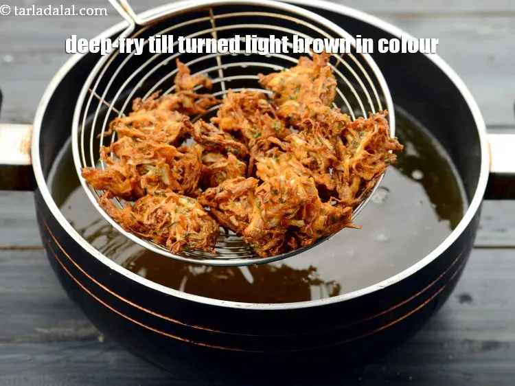 Step 14 – When the cabbage pakodas have turned light brown in color from one side, gently flip …