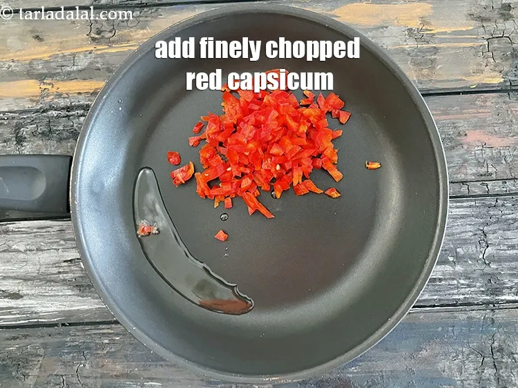 स्टेप 15 – १/२ कप&nbsp;बारीक&nbsp;<a href=""https://www.tarladalal.com/glossary-chopped-red-capsicum-hindi-2299i"">कटी लाल शिमला मिर्च</a>&nbsp;डालें&nbsp;&nbsp;।