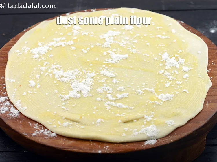 स्टेप 13 – थोड़ा&nbsp;<a href=""https://www.tarladalal.com/glossary-plain-flour-maida-188i"" style=""font-family:Arial; font-size:16px; font-style:normal; font-variant-ligatures:normal; font-weight:400; text-align:left; white-space:normal; background-color:#ffffff"">मैदा</a>&nbsp;छिड़कें&nbsp;।