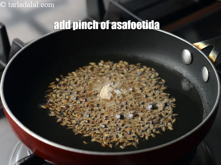 Step 13 – When the seeds crackle, add a pinch of <a href="https://www.tarladalal.com/glossary-asafoetida-hing-113i">asafoetida (hing)</a>.