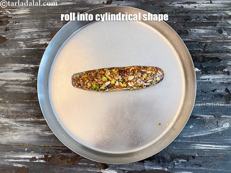 स्टेप 16 – अब बर्फी के मिश्रण को आटे में मिला लीजिए।&nbsp;बेलनाकार आकार …