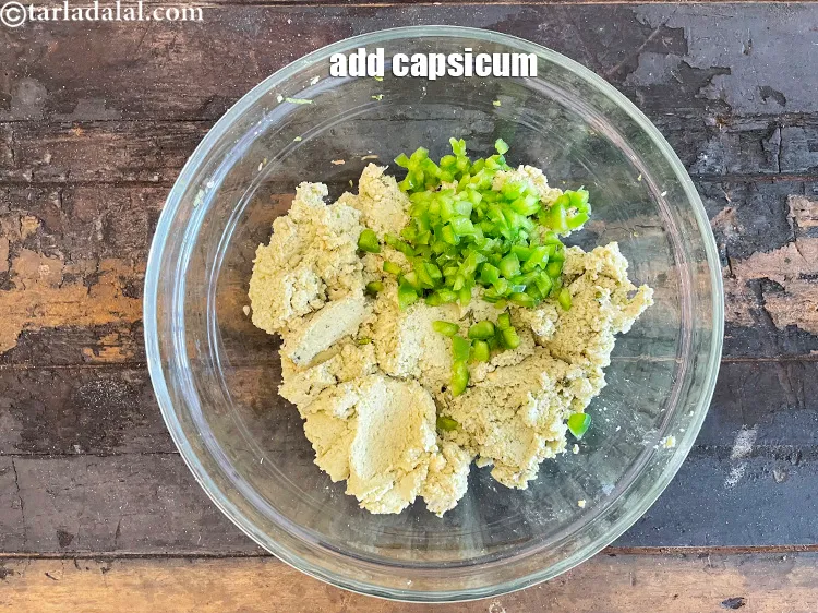 स्टेप 15 – १/४ कप बारीक <a href=""https://www.tarladalal.com/glossary-chopped-capsicum-hindi-164i"">कटी हुई शिमला मिर्च</a> डालें।