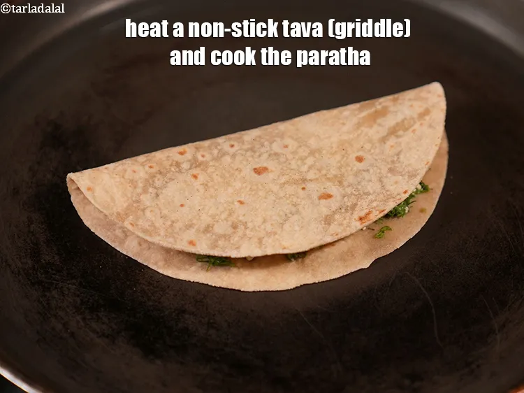 Step 14 – Heat a non-stick tava (griddle) and cook the paratha.