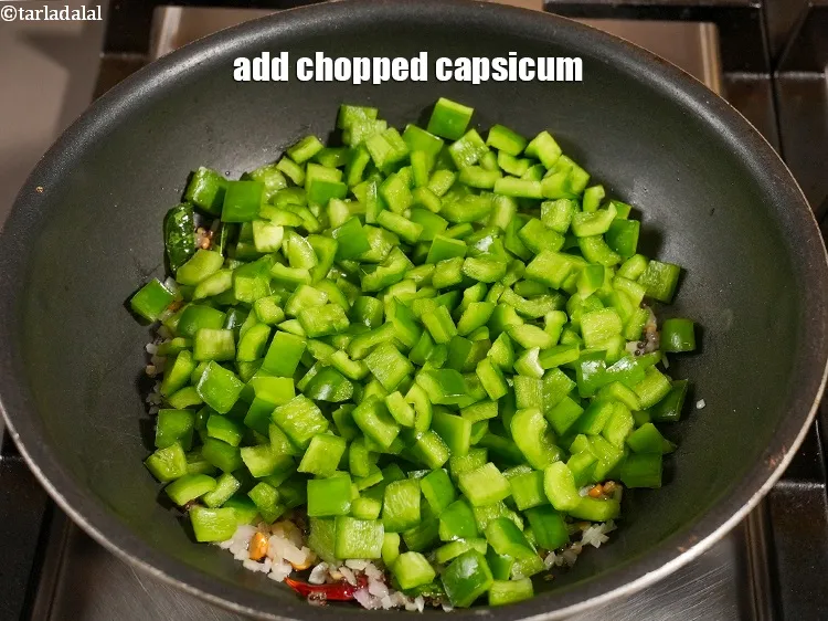 Step 14 – Add 2&frac12; cups <a href="https://www.tarladalal.com/glossary-chopped-capsicum-164i">chopped capsicum</a>.