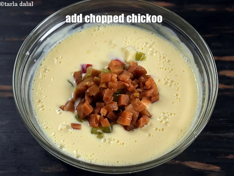 Step 14 – Add &frac12; cup <a href="https://www.tarladalal.com/glossary-chopped-chickoo-846i">chopped chickoo</a>.