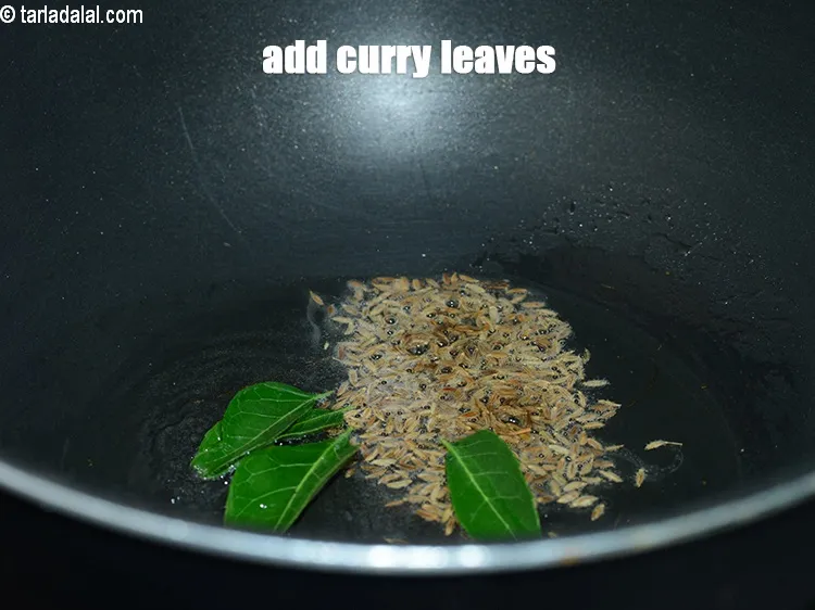 Step 14 – When the seeds crackle, add 2 to 3 <a href="https://www.tarladalal.com/glossary-curry-leaves-kadi-patta-kadipatta-388i">curry leaves (kadi patta)</a>.
