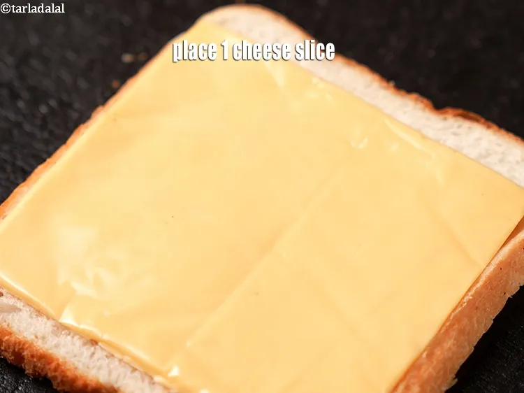 Step 14 – Place 1 <a href="https://www.tarladalal.com/glossary-cheese-slices-765i">cheese slice</a>&nbsp;over the bread.
