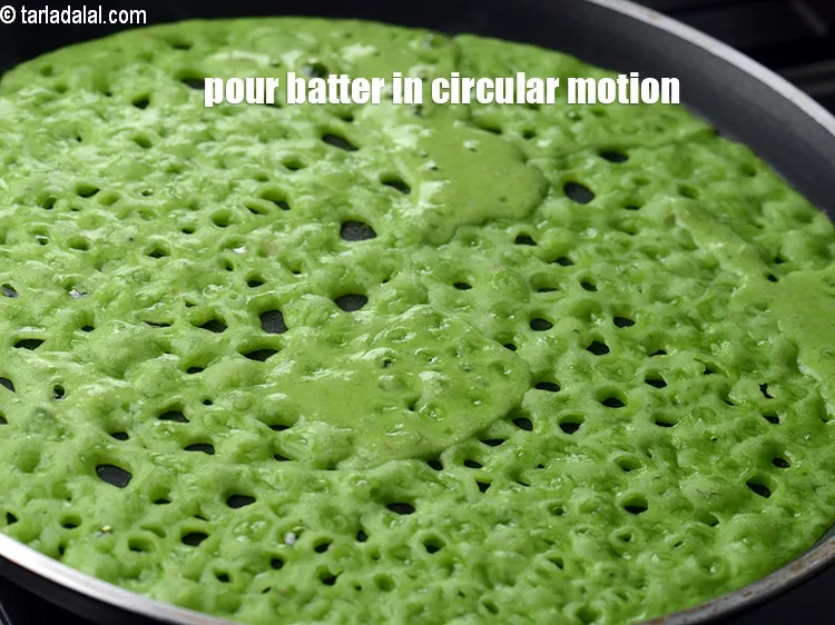 Step 14 – Once the tava is greased properly, pour the batter using a ladle from the edges …