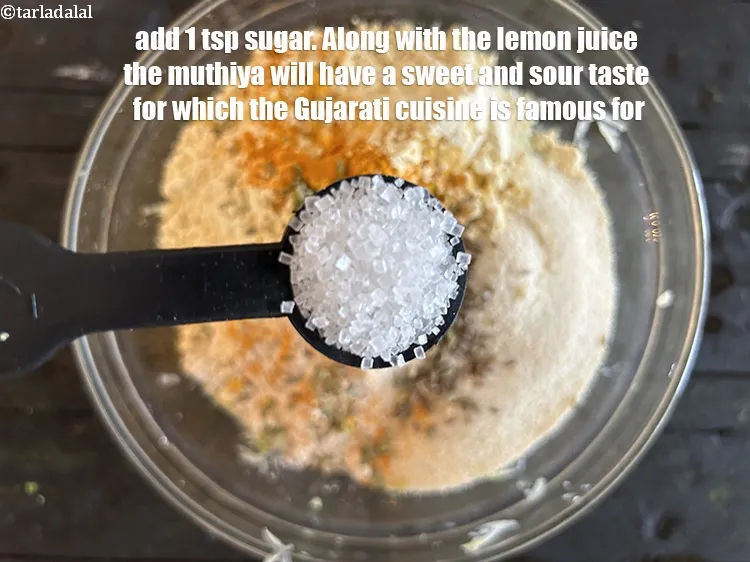 स्टेप 14 – १ टी-स्पून&nbsp;<a href=""https://www.tarladalal.com/glossary-sugar-chini-shakkar-hindi-278i"">शक्कर</a>&nbsp;डालें।&nbsp;नींबू के रस के साथ-साथ मुठिया में खट्टा-मीठा …