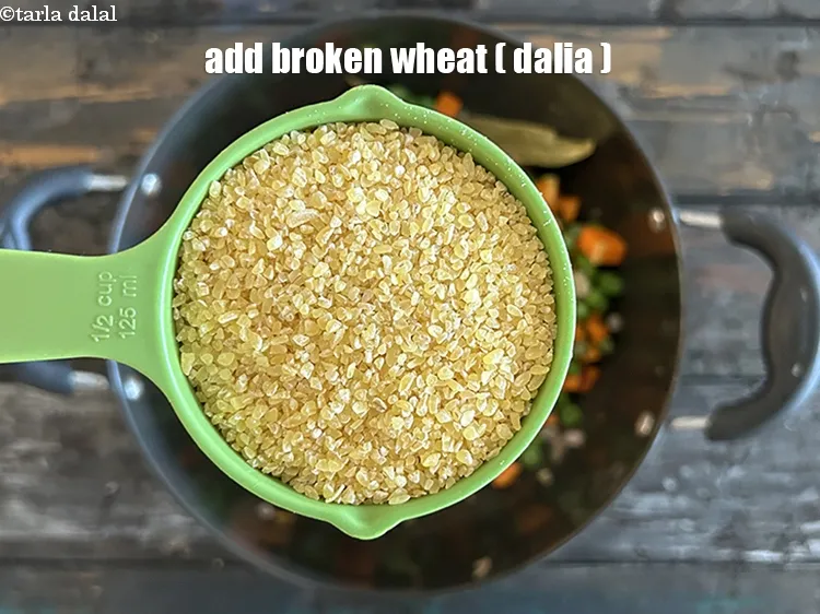 Step 14 – Add&nbsp;<meta charset="UTF-8" />1/2 cup&nbsp;<a href="glossary-broken-wheat-dalia-bulgur-wheat-lapsi-fada-426i">broken wheat (dalia)</a>.
