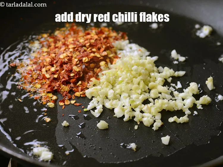 Step 14 – Add 1&frac12; tsp <a href="https://www.tarladalal.com/glossary-dry-red-chilli-flakes-paprika-338i">dry red chilli flakes (paprika)</a>.