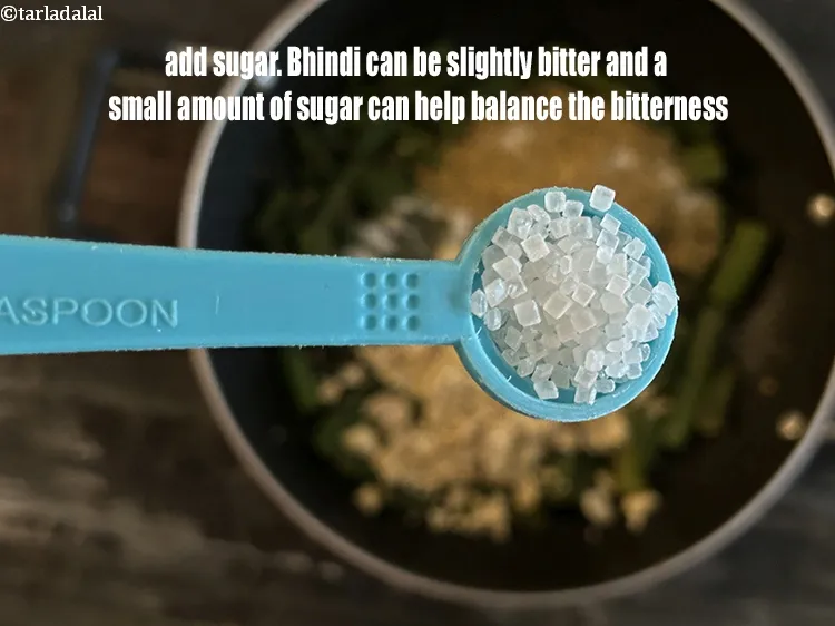 स्टेप 19 – १/२ टी-स्पून&nbsp;<a href=""https://www.tarladalal.com/glossary-sugar-chini-shakkar-hindi-278i"">शक्कर</a>&nbsp;डालें।&nbsp;भिंडी का स्वाद थोड़ा कड़वा या घास जैसा …