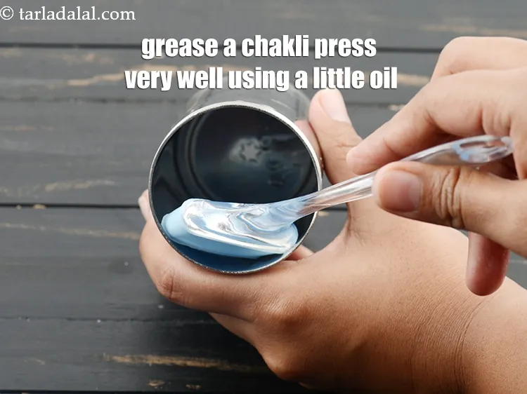 Step 14 – To make <strong>ragi chakli recipe | nachni chakli | ragi murukku</strong>, grease a chakli press …