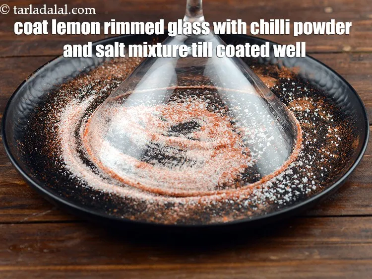 Step 13 – Coat the lemon rimmed glass with chilli powder and salt mixture till its coated well.