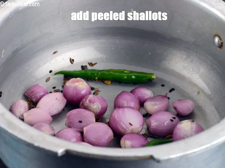 Step 14 – Add &frac12; cup peeled <a href="https://www.tarladalal.com/glossary-shallots-madras-onions-827i">shallots (madras onions)</a>.