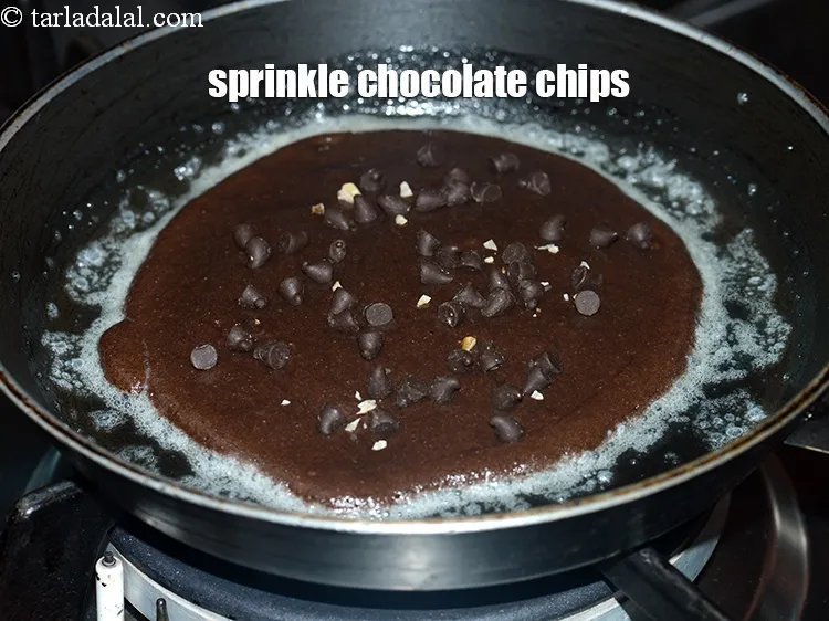 Step 14 – Sprinkle &frac12; tbsp of <a href="https://www.tarladalal.com/glossary-chocolate-chips-325i">chocolate chips</a>.