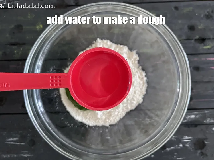 स्टेप 14 – पानी धीरे-धीरे डालें।&nbsp;आटा लगाने में हमने 2.5 टेबल स्पून पानी …