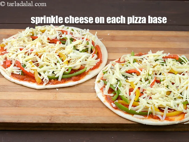 Step 22 – Sprinkle 1/2 cup&nbsp;<a href="https://www.tarladalal.com/glossary-grated-mozzarella-cheese-1022i">grated mozzarella cheese</a>&nbsp;or&nbsp;<a href="https://www.tarladalal.com/glossary-grated-processed-cheese-868i">grated processed cheese</a> evenly on each pizza base.