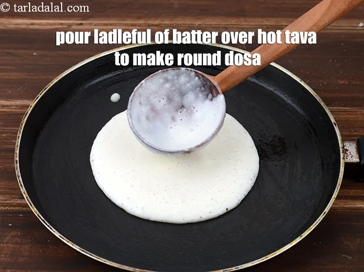 Step 14 – Pour a ladleful of the batter over the hot tava to make a 125 mm. …