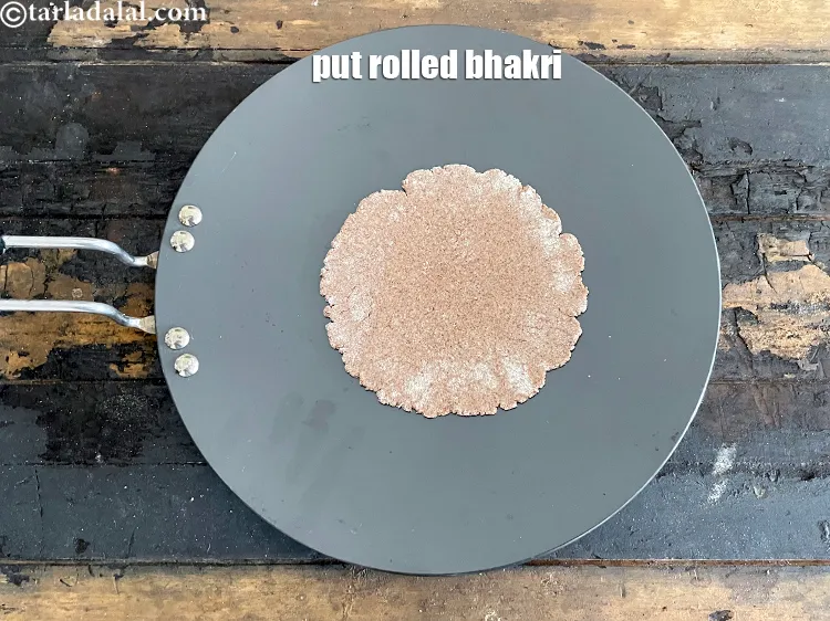 Step 25 – Place the rolled out&nbsp;multigrain bhakri &nbsp;to cook it.