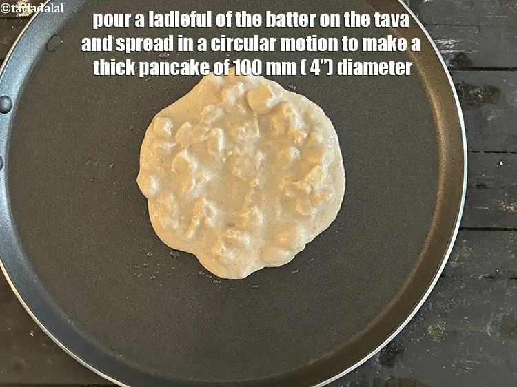 Step 20 – <meta charset="UTF-8" />Pour a ladleful of the batter on the tava&nbsp;and spread in a circular …