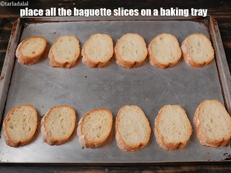 Step 15 – Place all the <a href="https://www.tarladalal.com/glossary-sliced-baguette-1545i">baguette slices</a> on a baking tray.