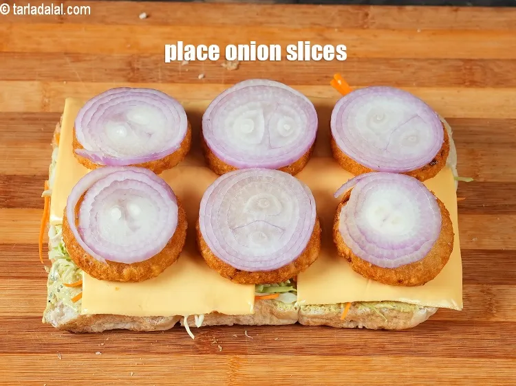 Step 18 – Place 6 <a href="https://www.tarladalal.com/glossary-onion-slices-2432i">onion slices</a> over it.