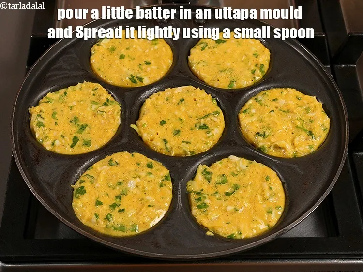 Step 29 – Pour a little batter in an uttapa mould.&nbsp;Spread it lightly using a small spoon.&nbsp;