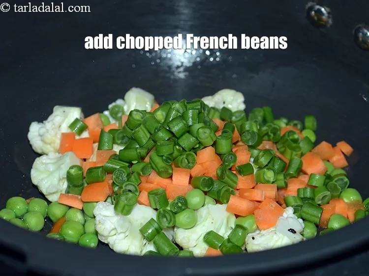 Step 16 – Add &frac14; cup <a href="https://www.tarladalal.com/glossary-chopped-french-beans-797i">chopped french beans</a>.