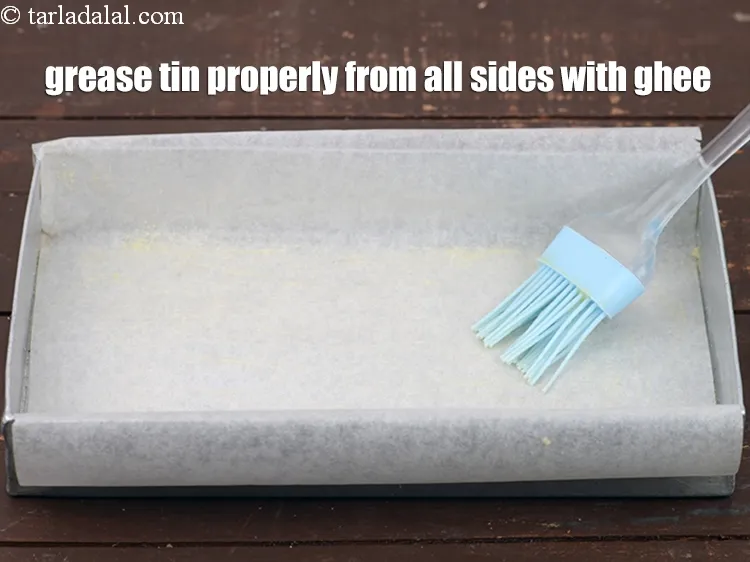 Step 16 – Grease the tin properly from all the sides with ghee using a brush.