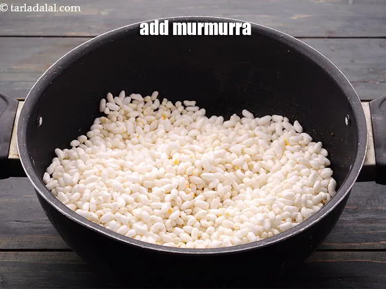 Step 15 – Switch on the flame, add the <a href="https://www.tarladalal.com/glossary-puffed-rice-kurmura-murmura-mamra-537i#ing_2452" target="_blank">murmurra</a>.