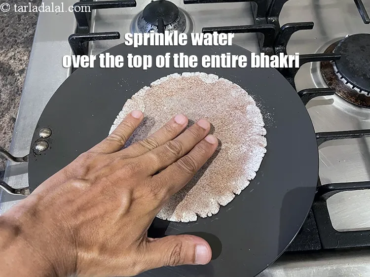Step 16 – Sprinkle water on the top of the entire bhakri.