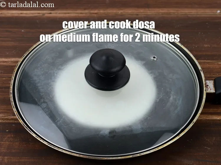 Step 15 – Cover and cook the dosa on medium flame for 2 minutes.