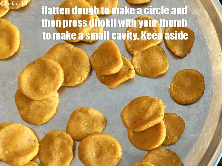 Step 15 – Flatten the dough pieces to make&nbsp;a circle and then press the dhokli with your thumb …