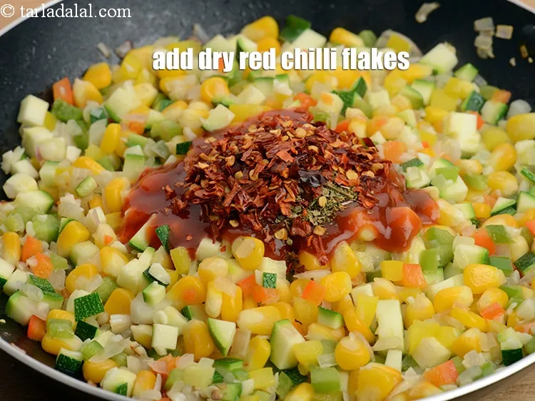 Step 18 – Add 2 tsp <a href="https://www.tarladalal.com/glossary-dry-red-chilli-flakes-paprika-338i">dry red chilli flakes (paprika)</a>.