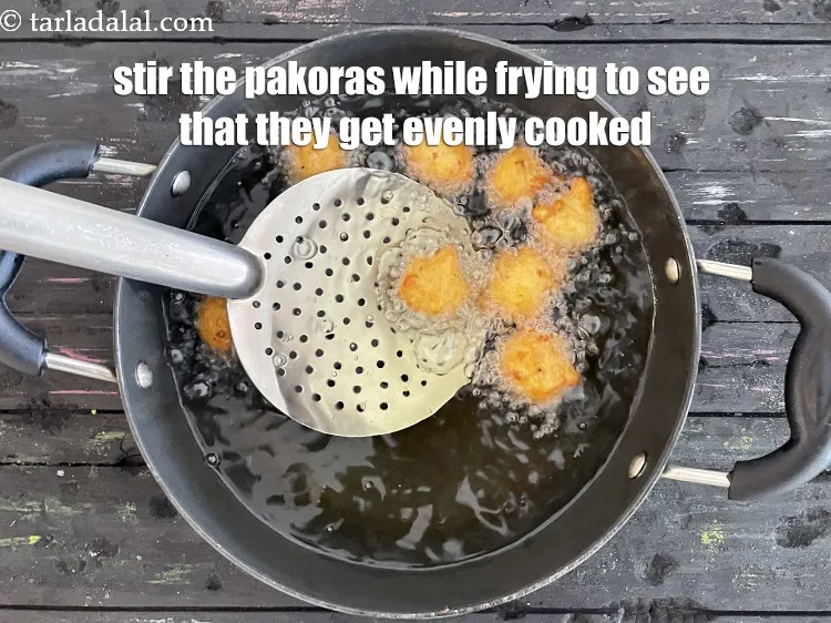 Step 22 – Stir&nbsp;the pakoras with a slotted spoon&nbsp;while frying to see that they get evenly cooked.