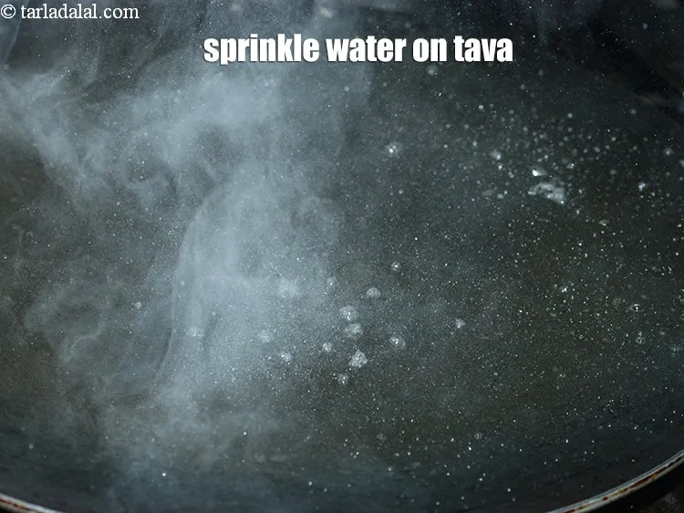 Step 15 – Sprinkle a little water on the tava (griddle).